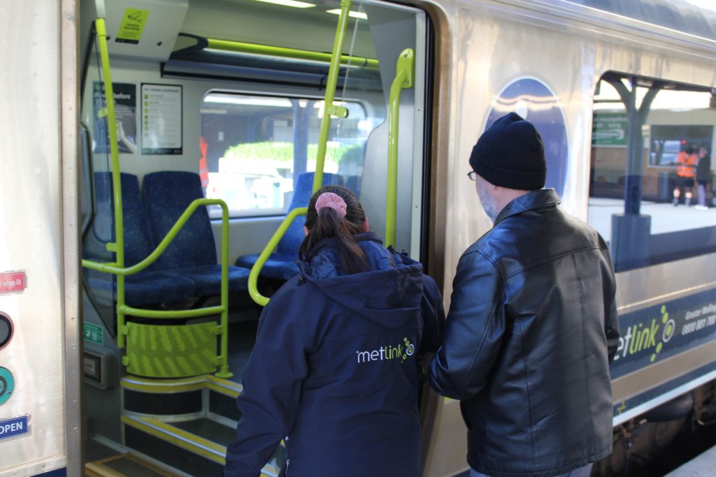 Image of Wellington rail employee assisting passenger to board