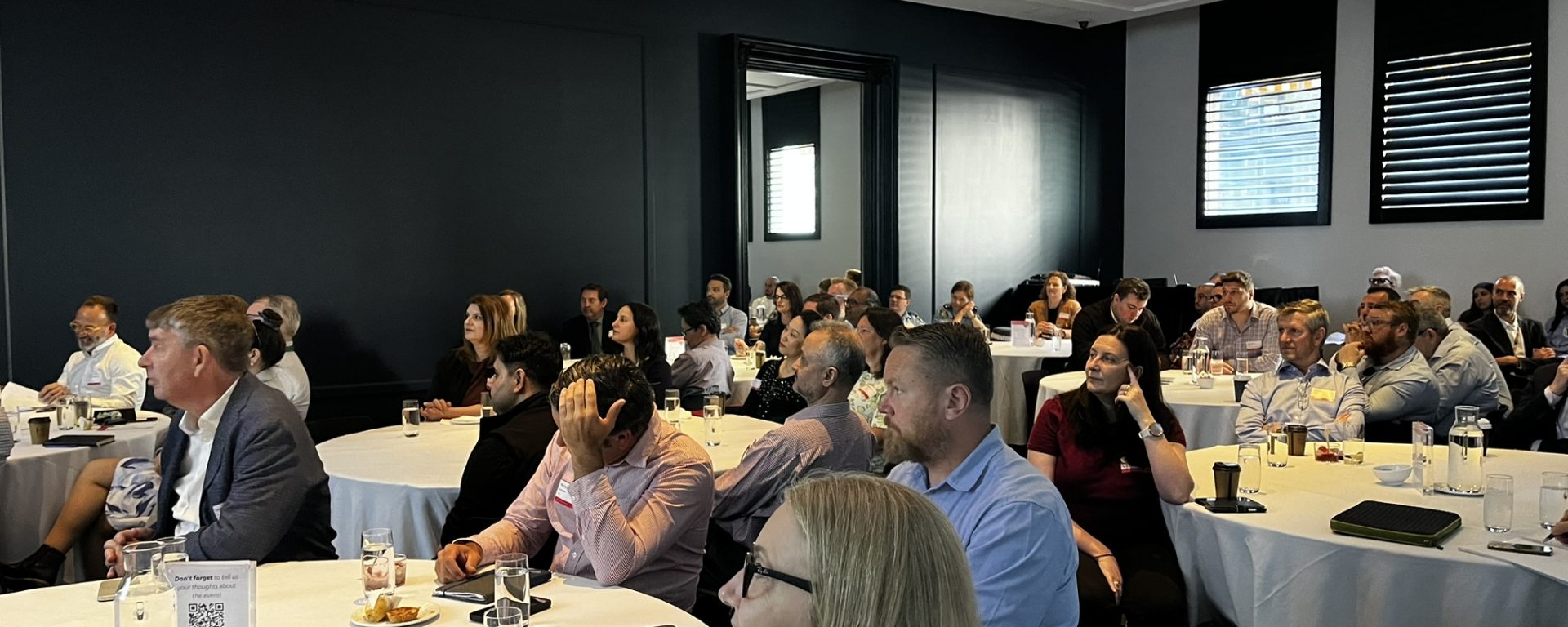 Audience of Transdev Australia and New Zealand employees seated at round tables listening attentively during the 2025 Transdev Sydney Light Rail Safety Forum.